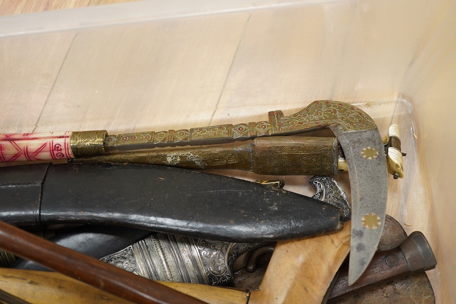 Eighteen assorted world weapons comprising a silver jambya (pommel missing), a knobkerry, a dha, two kris (one with handle missing), a lohar, three kukris, a djambok, a Chinese trousse, a chora, a flyssa, five others and
